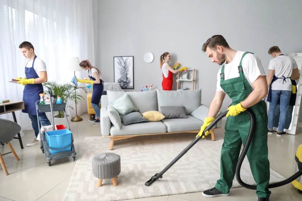 Professional cleaners performing residential home cleaning in a modern living room.