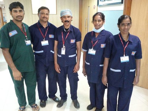 Housekeeping team performing dusting and mopping in a modern living room